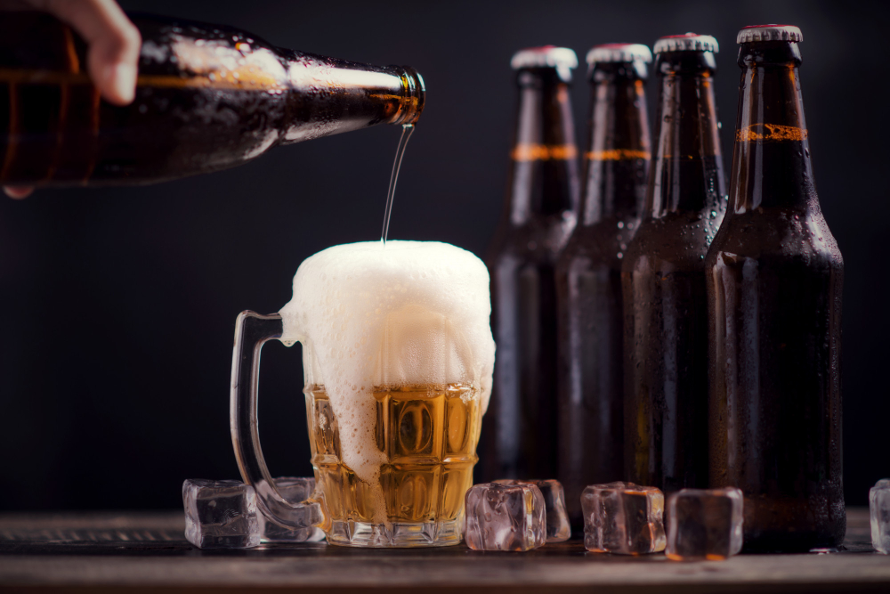 O prazer de beber com os amigos: benefícios 4 garrafas de vidro de cerveja com vidro e gelo no fundo escuro